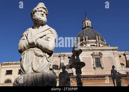 Statua sulla Fontana di Pretoria (detta anche Fontana della vergogna) in Piazza Pretoria con la Chiesa di Santa Caterina sullo sfondo Foto Stock