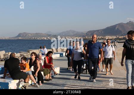 I pedoni passeggiano lungo la passeggiata sul lungomare di Palermo, in Sicilia Foto Stock