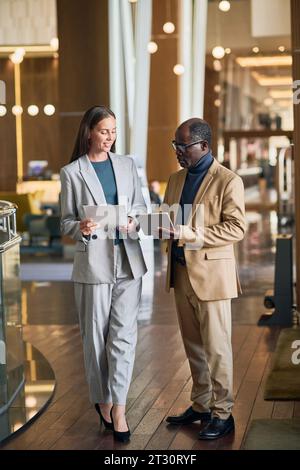 Immagine verticale dei colleghi che discutono di lavoro durante la riunione in hotel Foto Stock