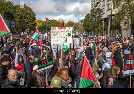 Londra / Regno Unito - 21 ottobre 2023: Centinaia di migliaia di manifestanti pro-palestinesi marciano con cartelli e bandiere per una manifestazione contro l'attacco israeliano Foto Stock