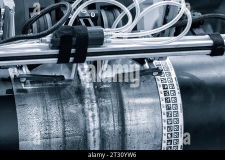 Apparecchiature industriali a ultrasuoni e a raggi X per testare la qualità di una saldatura su un tubo metallico di grande diametro, concetto industriale Foto Stock