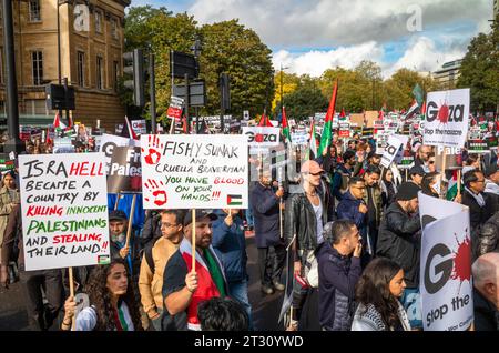 Londra / Regno Unito - 21 ottobre 2023: Centinaia di migliaia di manifestanti pro-palestinesi marciano con cartelli e bandiere per una manifestazione contro l'attacco israeliano Foto Stock