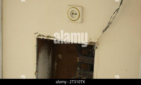 Vecchio scudo elettrico nel muro della vecchia casa. Stock di filmati. Fili con bolletta e presa nella parete della vecchia casa. Impianto elettrico della vecchia casa del villaggio Foto Stock