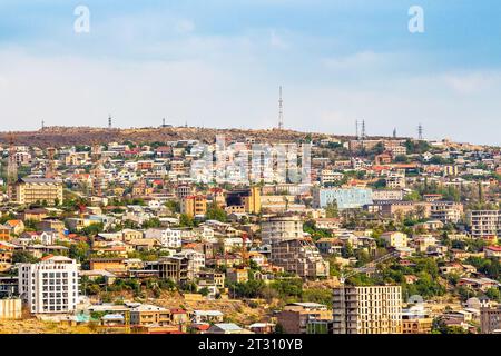 Erevan, Armenia - 29 settembre 2023: Case urbane nella città di Erevan illuminate dal sole, vista dalle scale delle cascate al tramonto autunnale Foto Stock