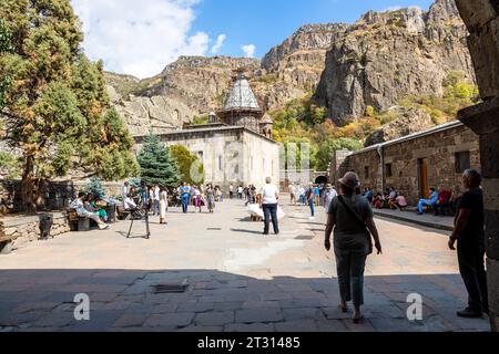 Goght, Armenia - 30 settembre 2023: Gente nel cortile del Monastero di Geghard nell'alta Valle di Azat in soleggiato giorno autunnale. Geghard è patrimonio dell'umanità dell'UNESCO Foto Stock