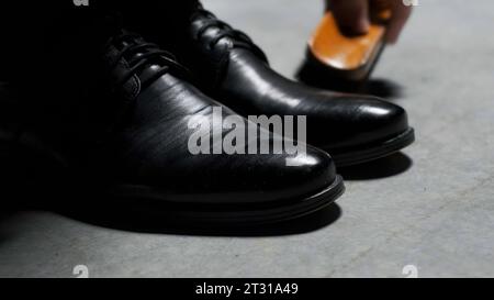 Scarpe classiche nere in pelle cerata. Stock di filmati. Primo piano degli stivali per la pulizia e la lucidatura. Foto Stock