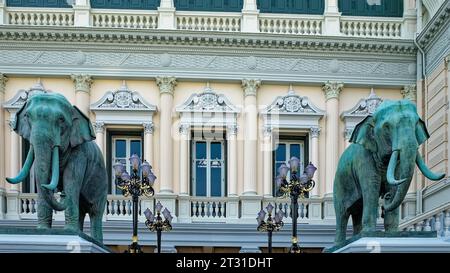 Una scala in pietra adornata da due statue di elefanti a grandezza naturale, con lampioni su entrambi i lati, conduce ad un elegante edificio di colore chiaro. Foto Stock