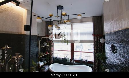 Bagno moderno ed elegante. Creativo. Interno di un bagno moderno con dettagli e piante. Piante in un bagno elegante e finestre panoramiche Foto Stock
