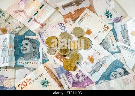 Macro primo piano delle monete in peso colombiano su banconote di diversi tagli Foto Stock