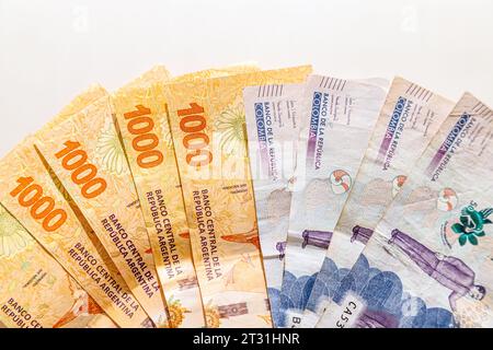Pesos colombiani e argentini a forma di ventaglio su sfondo bianco Foto Stock