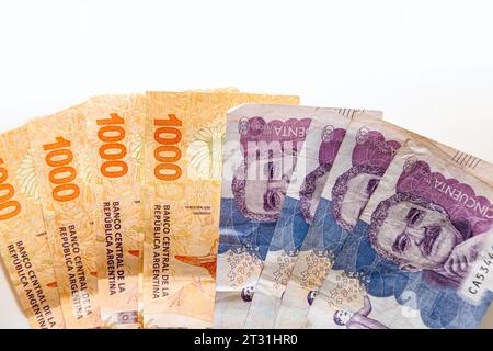 Pesos colombiani e argentini a forma di ventaglio su sfondo bianco Foto Stock