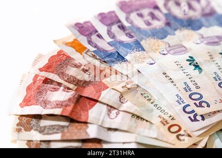 Macro primo piano di pesos colombiani di diverso valore a forma di ventaglio su sfondo bianco Foto Stock