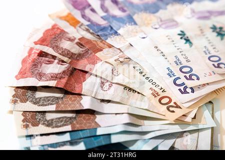 Macro primo piano di pesos colombiani di diverso valore a forma di ventaglio su sfondo bianco Foto Stock