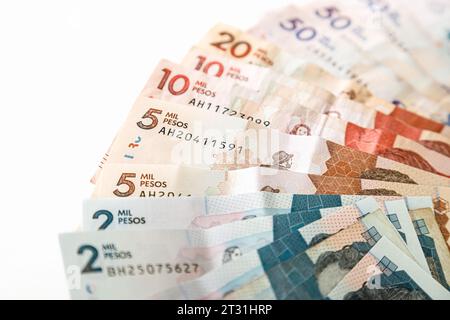 Macro primo piano di pesos colombiani di diverso valore a forma di ventaglio su sfondo bianco Foto Stock