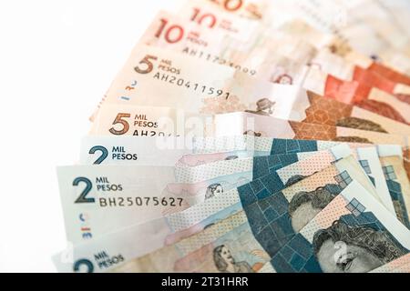 Macro primo piano di pesos colombiani di diverso valore a forma di ventaglio su sfondo bianco Foto Stock