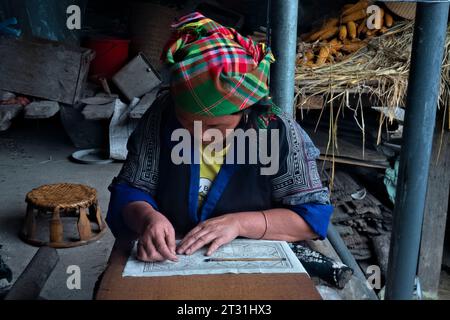 Una donna Flower Hmong disegna un modello per il suo ricamo tradizionale, Mu Cang Chai, Yen Bai, Vietnam Foto Stock