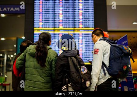 Bogotà, Colombia - 8 gennaio 2023: I passeggeri controllano il loro volo di fronte alla schermata arrivi e partenze all'aeroporto El Dorado Foto Stock