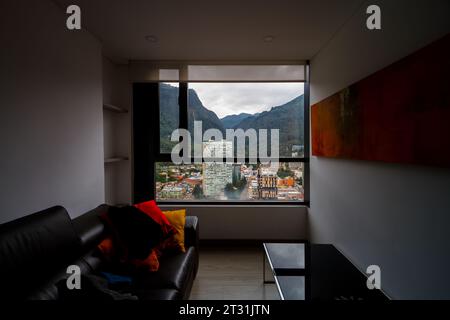 Edifici residenziali con una collina sullo sfondo visti da una finestra di un appartamento a Bogotà, Colombia Foto Stock