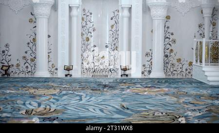 Fantastico interno della sala di preghiera nella moschea di Istanbul, Turchia. Scena. Incredibile motivo floreale bianco e dorato sulle pareti e blu sul pavimento. Foto Stock