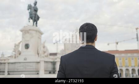 Un bell'uomo in completo cammina lungo la strada il giorno d'estate. Azione. Un uomo attraente in completo va in data o in occasione di un evento. Un uomo elegante in completo cammina con sicurezza Foto Stock