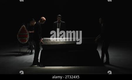 Produzione teatrale in camera oscura. Stock di filmati. Funerale sul palco con attori. Messa in scena teatrale del funerale in camera oscura con attori e. Foto Stock