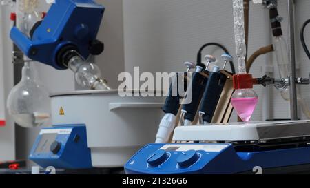 Apparecchiature in laboratori chimici con matracci rotanti. Stock di filmati. Apparecchiatura rotante e liquido colorato in matraccio in laboratorio. Chimica Foto Stock