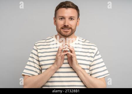 Allegro e amichevole uomo di mezza età non rasato, con una visione approfondita e un'idea che guarda la fotocamera sorridendo piacevolmente Foto Stock
