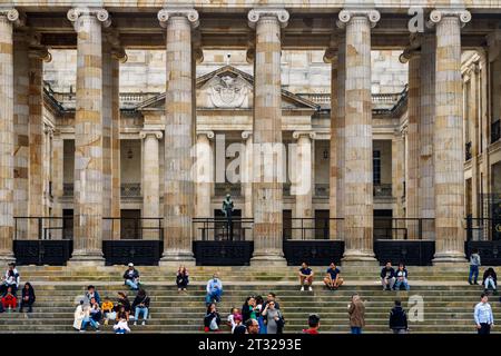 Bogotà, Colombia - 1° gennaio 2023: Decine di turisti siedono sui gradini del Campidoglio nazionale in Plaza Bolivar, la piazza principale di Bogotà Foto Stock