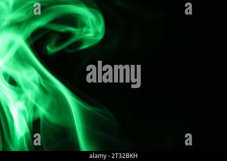 Fumo verde su sfondo scuro, astratto colorato, nebbia verde, sfondo minimalista Foto Stock