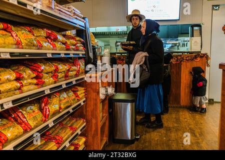 Gli Amish fanno shopping al Doud's Market, il più antico negozio di alimentari d'America. Il negozio ha aperto a Mackinac Island nel 1884. Gli Amish si sentono come a casa sull'isola senza auto, che sembra essere caduta fuori dal tempo, proprio come lo stile di vita Amish. Gli Amish tradizionali e originali sono popolari sull'isola di Mackinac a causa della loro abilità artigianale, ad esempio nella costruzione e riparazione di carrozze. Con i loro abiti, si distinguono difficilmente nel Doud's Market, il più antico negozio di alimentari d'America. Mackinac Island, Michigan, Stati Uniti Foto Stock