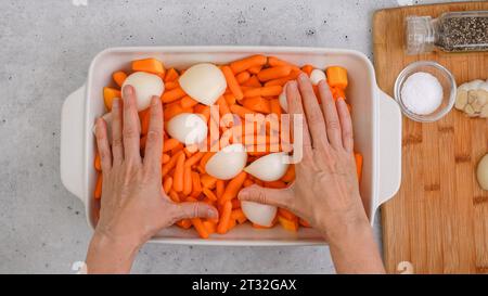 Ricetta per zuppa di zucca arrostita. Cubetti di zucca sbucciati e senza semi, carota, cipolla, aglio e spezie da vicino in una teglia da forno in ceramica inclusa nel kit Foto Stock
