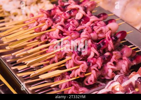 Esposizione di spiedini di calamari crudi al famoso mercato del pesce di Nishiki a Kyoto, Giappone Foto Stock