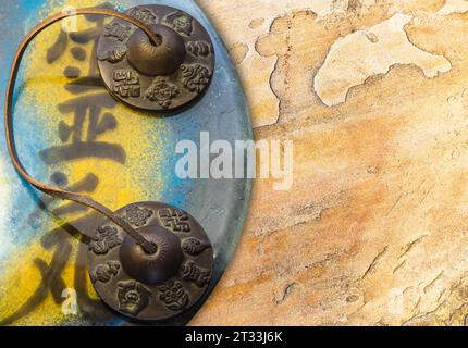 Vista dall'alto del simbolo Reiki con campana tibetana e sfondo di struttura rocciosa. Foto Stock