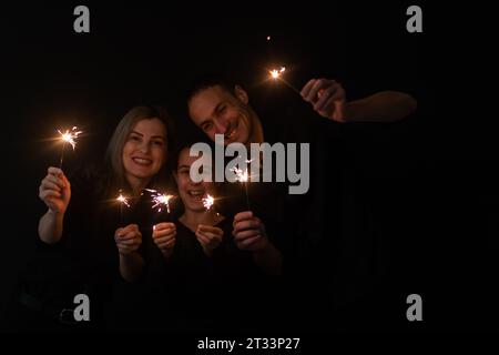 famiglia con scintillanti su sfondo nero Foto Stock