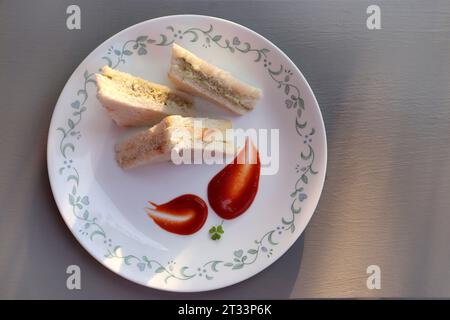 Panino semplice con formaggio e chutney servito con ketchup di pomodoro, menta verde e salsa di coriandolo. giardino di fondo. Vista piatta o dall'alto. Foto Stock