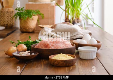 Carne macinata e ingredienti per polpette fatte in casa su un tavolo Foto Stock