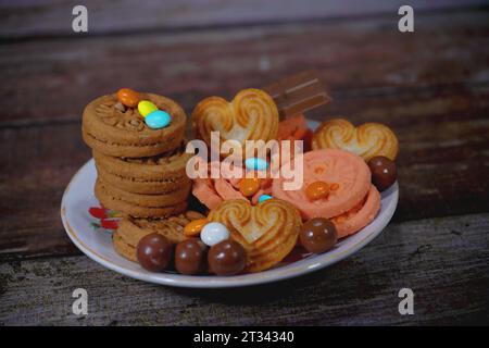 Su un piatto vengono collocati dei biscotti, delle fette di torta al cioccolato Foto Stock