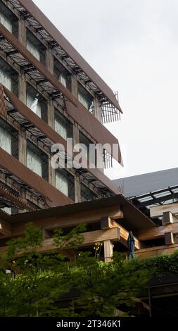Un primo piano di un edificio dall'aspetto moderno circondato da alberi lussureggianti in primo piano Foto Stock