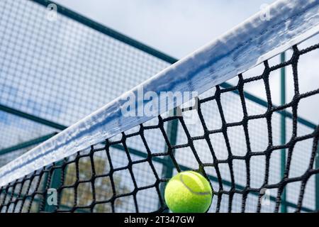 palla che colpisce la rete di un campo da paddle tennis, racquet sport concept Foto Stock