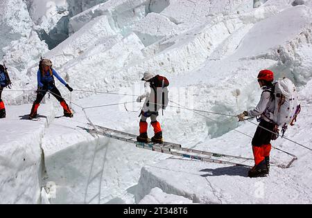 Alpinisti che attraversano un crepaccio sull'Everest. Foto Stock