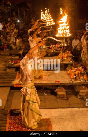 I sacerdoti indù raccolgono grandi lampade aarti durante il Ganga Aarti a Dashaswamedh ghat, Varanasi, Uttar Pradesh, India Foto Stock