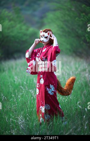 ragazza in maschera con coda di volpe all'aperto Foto Stock