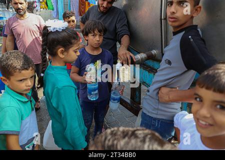 Gaza. 22 ottobre 2023. I bambini prendono l'acqua in una scuola di accoglienza nella parte meridionale della Striscia di Gaza, nella città di Khan Younis, 22 ottobre 2023. Il bilancio delle vittime dei palestinesi per attacchi aerei israeliani sulla Striscia di Gaza è salito a 4.651, secondo il Ministero della salute gestito da Hamas domenica. Crediti: Rizek Abdeljawad/Xinhua/Alamy Live News Foto Stock