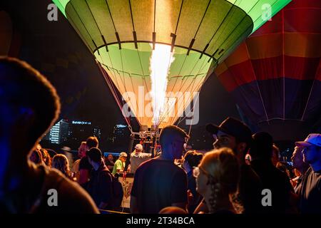 La mongolfiera si illumina mentre le persone si radunano intorno Foto Stock