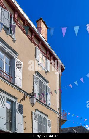 Guardando verso l'alto le iconiche case francesi con persiane blu in Rue Dalesme, a Limoges, nella regione francese Nouvelle-Aquitaine. Anche con un bel bunting! Foto Stock