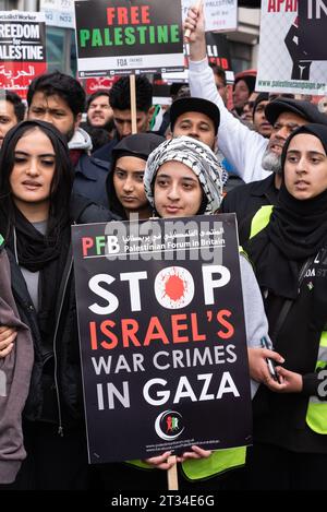 Cartello sui crimini di guerra in una protesta per la Palestina libera a Londra in seguito all'escalation del conflitto in Israele e Gaza. Giovani femmine Foto Stock