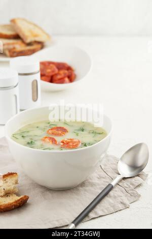 Tipica zuppa portoghese caldo Verde con pane e salsiccia chorizo su fondo bianco Foto Stock