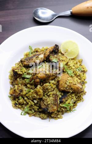 Il pollo Poha Bhujing è una prelibatezza di Virar, Maharashtra. Si tratta di pezzi di pollo arrostiti al carbone insieme alle patate, mescolati con poha spessa. Foto Stock