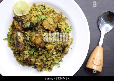 Il pollo Poha Bhujing è una prelibatezza di Virar, Maharashtra. Si tratta di pezzi di pollo arrostiti al carbone insieme alle patate, mescolati con poha spessa. Foto Stock