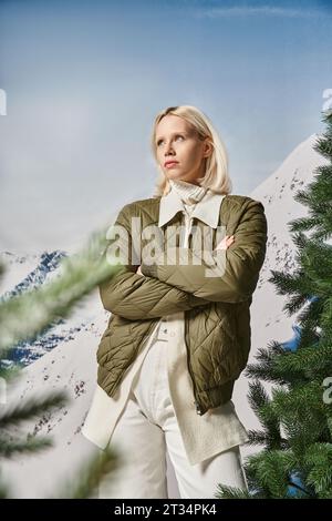 donna seria ed elegante in posa con le braccia incrociate sul petto e guardando lontano, moda invernale Foto Stock